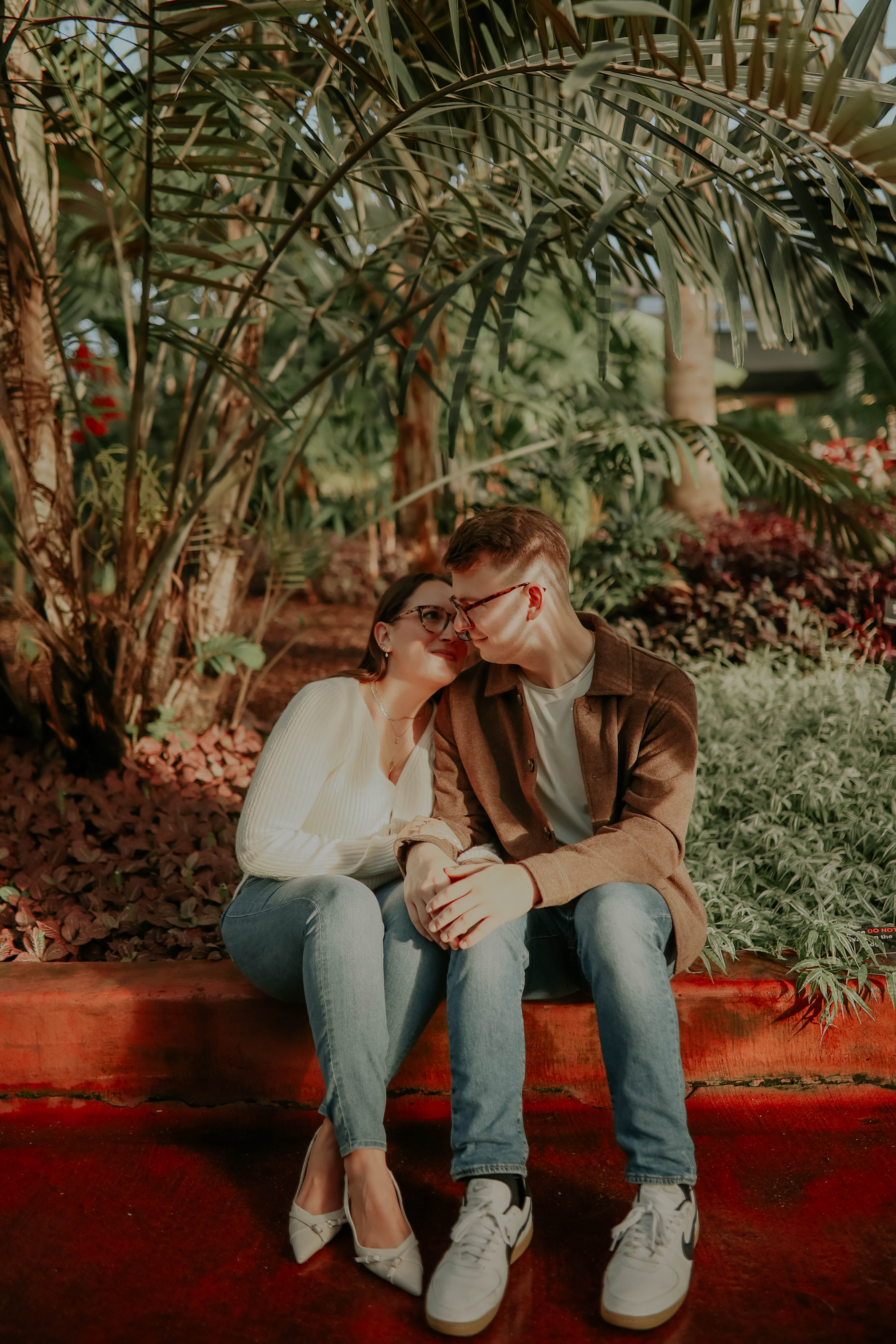 A loving couple sharing a kiss during their engagement photoshoot at Garfield Park Conservatory in Chicago.