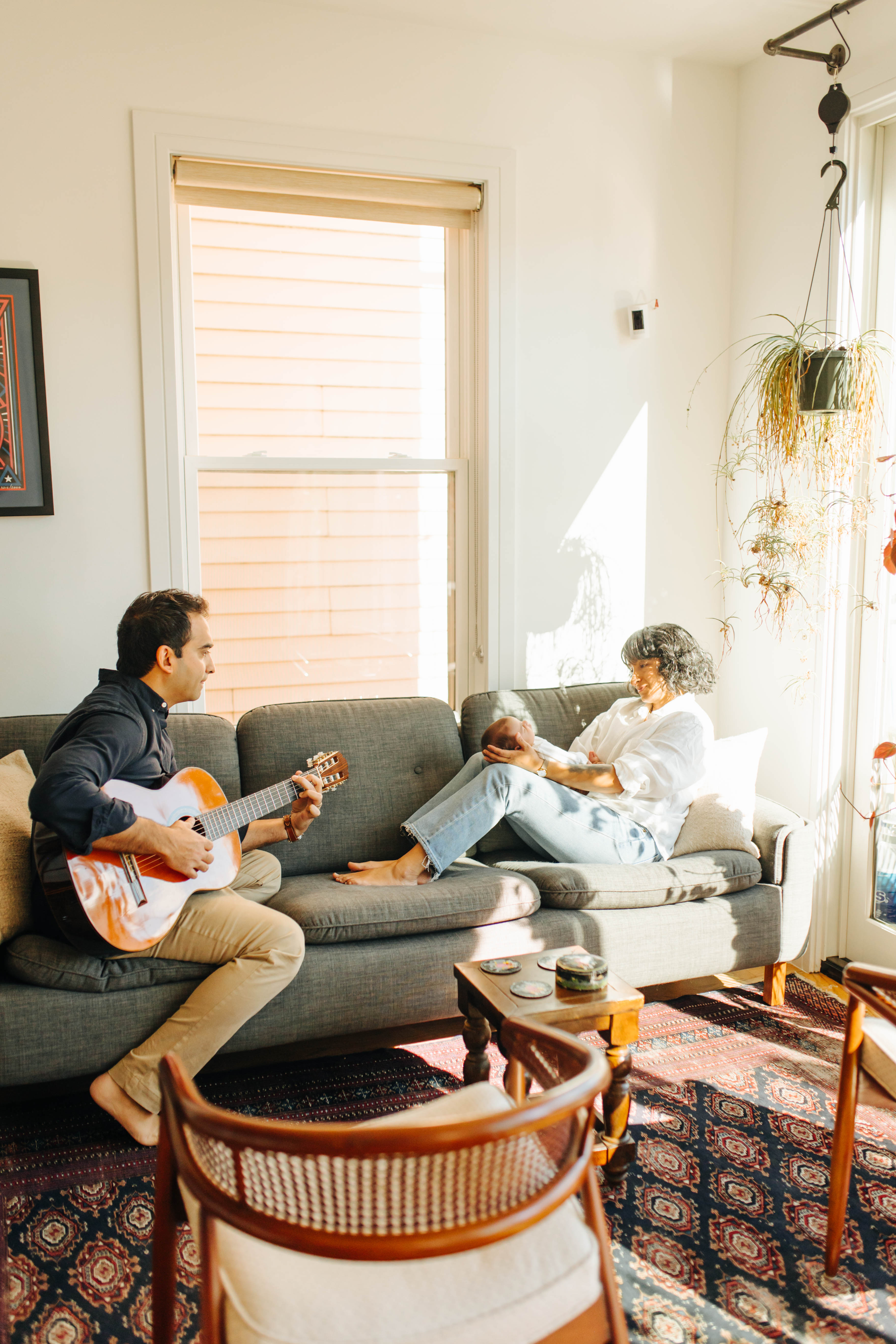 dad playing guitar to mother and son at home newborn photographer